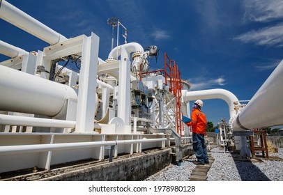Male worker inspection at steel long pipes   pipe elbow in station oil factory during refinery valve visual check record pipeline oil   gas industry