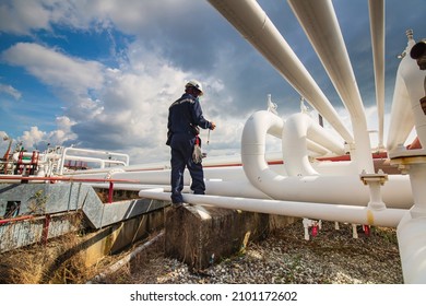 Male worker inspection at steel long pipes and pipe elbow in station oil factory during refinery valve of visual check record pipeline oil and gas industry.