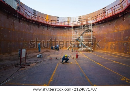 Male worker inspection vacuum test bottom plate tank new oil steel weld leak internal confined space.
