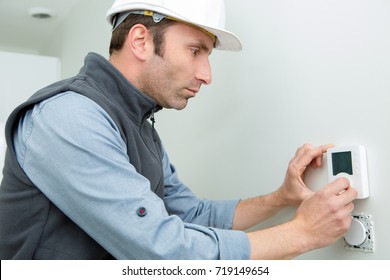 Male Worker Installing Thermostat