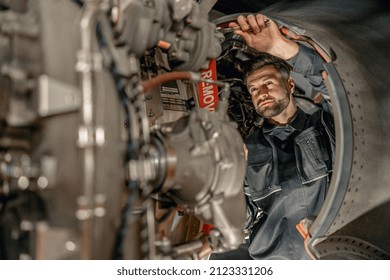 Male worker maintenance technician using wrench while repairing aircraft at repair station - Powered by Shutterstock