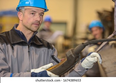 Male Worker Operating Heavy Machinery In Factory