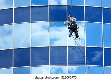 Male worker in overalls professional repair the windows in high-rise