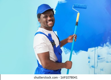 Male worker painting wall in room