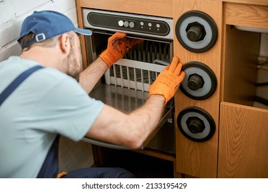 Male Worker Repairing Professional Equipment In Cafe