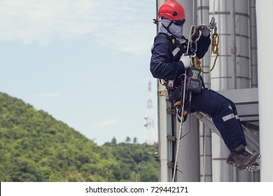 Male worker rope access  inspection of thickness storage tank industry below pipeline oil