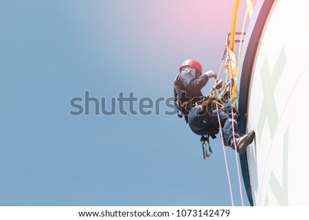 Male worker rope access  inspection of thickness storage  white tank industry
