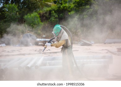 Male Worker Sandblasting Dust Process Cleaning Pipeline Surface On Steel Before Painting In The Factory.