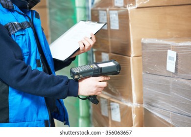 Male worker scanning package with barcode scanner in modern warehouse