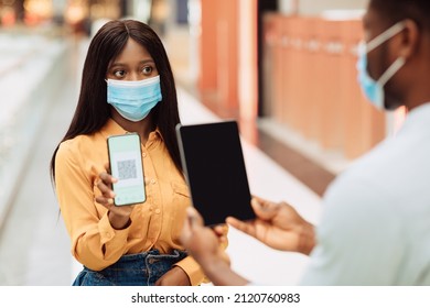 Male Worker Scanning Visitor's Health QR Code On Entrance To Public Place Using App On Digital Tablet, African American Woman In Protective Mask Showing Vaccination Certificate On Smartphone, Closeup