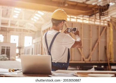 Male worker taking building photo with mobile phone