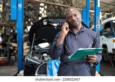 male worker talking on smartphone with customer in garage - Shutterstock ID 2208322457