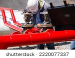 Male worker test ultrasonic flowing fire water hydrant pipes are installed flow rate test devices to measure the flow of water in steel pipes.