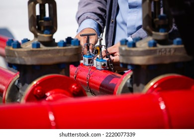 Male worker test ultrasonic flowing fire water hydrant pipes are installed flow rate test devices to measure the flow of water in steel pipes.