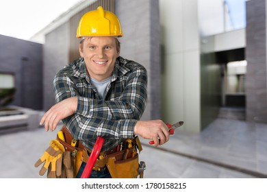 Male worker with tool belt and protective helmet - Shutterstock ID 1780158215