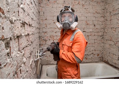 Male Worker Wearing Full Face Respirator Mask And Ear Defenders For Working In Dusty And Noisy Environment. 