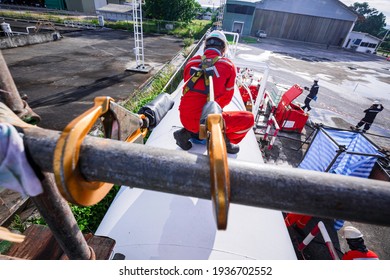 Male Worker Wearing Safety First Harness And Safety Lone Working At High Scaffold Place On Open Top Tank Roof Oil