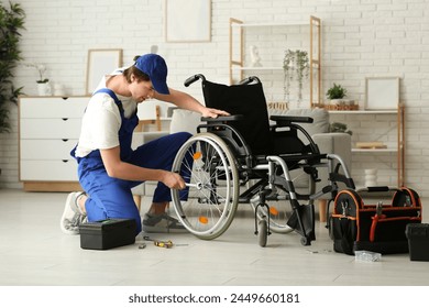 Male worker with wrench repairing wheelchair in room - Powered by Shutterstock