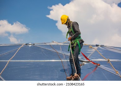 Male workers rope access height safety connecting with a knot safety harness, roof fall arrest and fall restraint anchor point systems ready to ascending, construction site oil tank dome - Shutterstock ID 2108423165