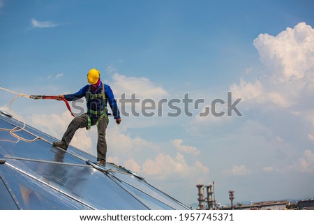 Male workers rope access height safety connecting with a knot safety harness, clipping into roof fall arrest and fall restraint anchor point systems ready to ascending, construction site oil tank dome
