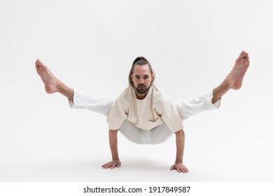 Male Yoga Teacher Practicing In Studio. Man Isolated On White Background Doing A Handstand