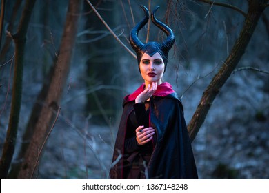 Maleficent Woman with Horns Posing in Spring Empty Forest with Smoky Background. Horizontal Orientation