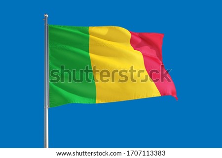 Mali national flag waving in the wind on a deep blue sky. High quality fabric. International relations concept.