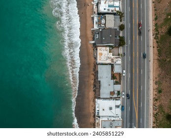 Malibu beach aerial view in California near Los Angeles, USA. Waves hitting the shore near expensive houses in Malibu.