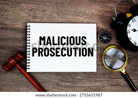 Malicious Prosecution message written on notepad with alarm clock, wood gavel and magnifying glass flat lay on wooden background