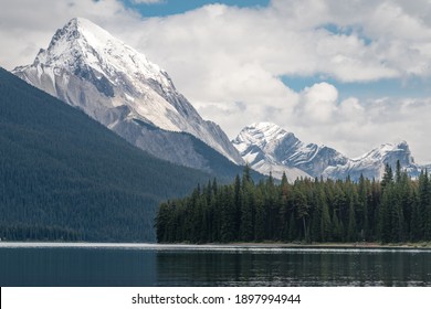 Maligne lake and Samson peak with Maligne mountain and Mount Paul in the background. Cloudy summer in Maligne valley of Jasper National Park, Alberta, Canada.