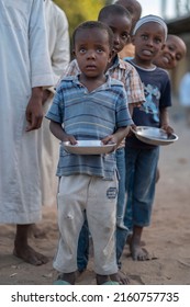 Malindi, Kenya - March 21 2021:Children waiting in line to buy food in Africa too. They are waiting for the plates in their hands.