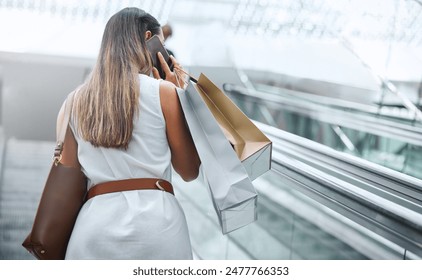 Mall, shopping bag and woman with phone call on escalator for retail, purchase and communication. Store, back and female person with tech in conversation for gift idea, clothes and update of discount - Powered by Shutterstock