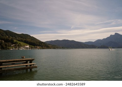 A mallard duck stands on a wooden pier on Lake Mondsee in September. Mondsee, Moon Lake, is a lake in the Upper Austrian part of the Salzkammergut, Austria - Powered by Shutterstock