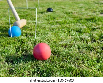 Mallet And Balls In Game Of Croquet On Green Lawn In Summer Day