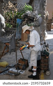 Mallorca, Spain; August 6, 2022: Senior Asian Gentleman Painting A Picture In The Street