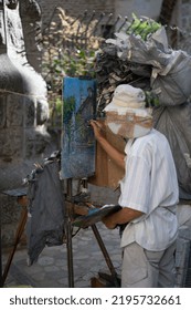 Mallorca, Spain; August 6, 2022: Senior Asian Gentleman Painting A Picture In The Street