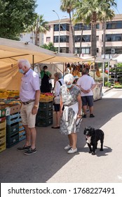 Calvià, Mallorca, Spain - June 13 2020: Senior Couple With Face Masks Walking Their Dog At A Neighborhood Street Market In Santa Ponça