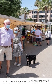 Calvià, Mallorca, Spain - June 13 2020: Senior Couple With Face Masks Walking Their Dog At A Neighborhood Street Market In Santa Ponça