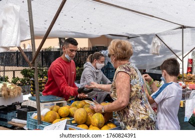 Calvià, Mallorca, Spain - June 15 2020: Older Woman With Face Mask Paying The Vendor At A Fruit Stall In The Flea Market Of The Town Of Calvia