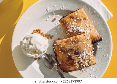 Maltese date filled pastry called Imqaret served and ice cream plate  