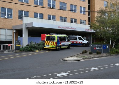 Malvern, Victoria, Australia - May 20 2022: Main entrance to Cabrini Hospital, with an ambulance and a patient transport vehicle parked near the emergency department entry
