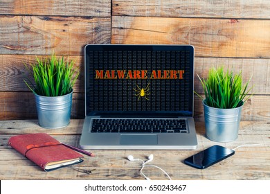 Malware alert in a laptop computer screen at the office.