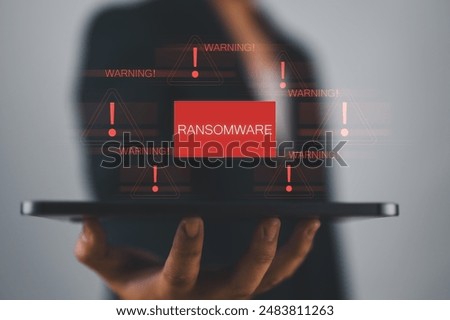 Malware attack virus alert. Person use tablet with virtual warning sign with ransomware word. warning notification, Cyber threats.