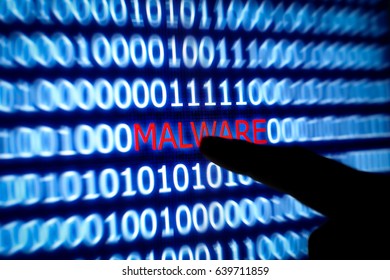 malware concept.Macro-close up of malware detection on led screen with blurred silhouette human finger