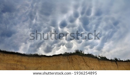 Mammatus unusual clouds ( marsupial, called Mastoid, umeshaped ) on sky over over the cliff