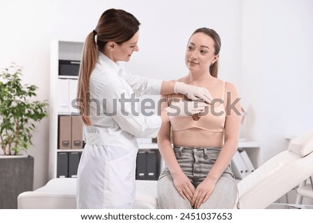 Mammologist checking young woman's breast in hospital