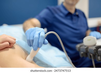 Mammologist doctor examines a woman breasts and lymph nodes using ultrasound. Mammography and ultrasound scanning are main methods of instrumental diagnosis of mammary glands. Breast cancer awareness - Powered by Shutterstock