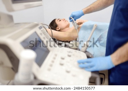 Mammologist doctor examines a woman breasts and lymph nodes using ultrasound. Mammography and ultrasound scanning are main methods of instrumental diagnosis of mammary glands. Breast cancer awareness
