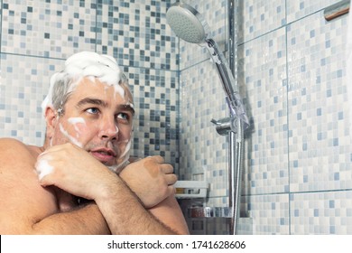 A Man Of 30-40 Years Old In A Foam Stands In The Bathroom, Clutching Himself With His Hands And Trembling From The Cold, Water Does Not Pour. Water Supply Failure