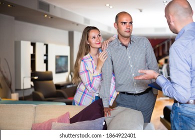 Man 40-45 Years Old And Woman 25-30 Years Old Are Consulting With Seller To Choose New Sofa For Home.